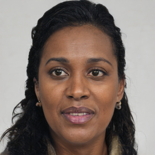 Joyful black young-adult female with long  black hair and brown eyes