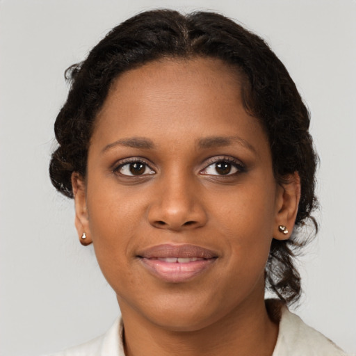 Joyful black young-adult female with short  brown hair and brown eyes