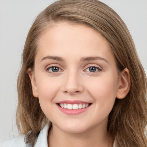 Joyful white young-adult female with long  brown hair and blue eyes