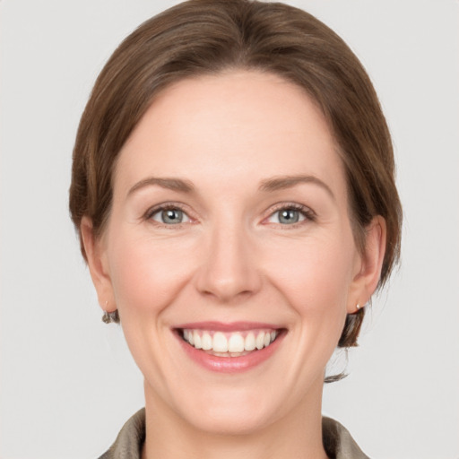 Joyful white young-adult female with medium  brown hair and grey eyes