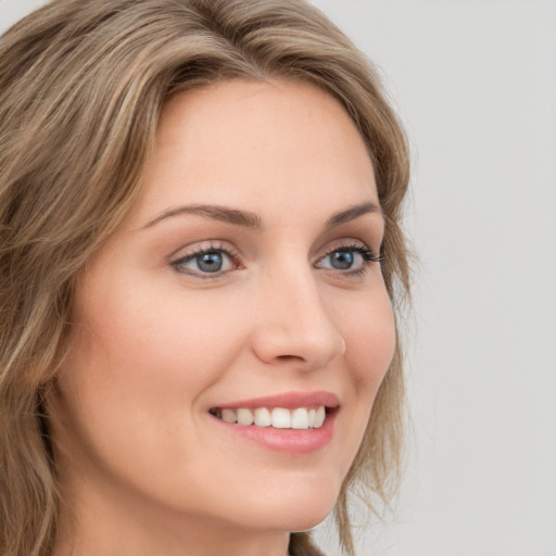 Joyful white young-adult female with long  brown hair and green eyes