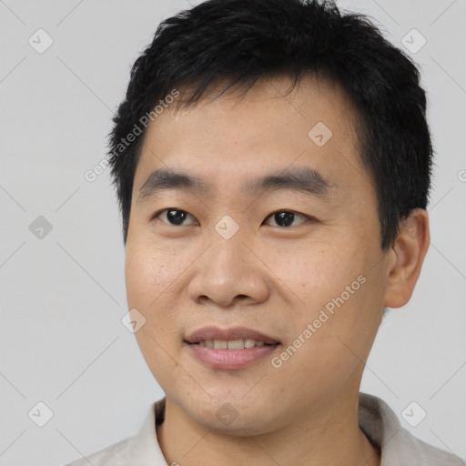 Joyful asian young-adult male with short  black hair and brown eyes