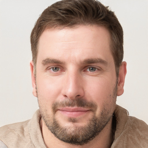 Joyful white young-adult male with short  brown hair and grey eyes