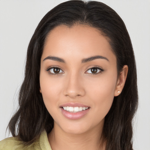 Joyful latino young-adult female with long  brown hair and brown eyes