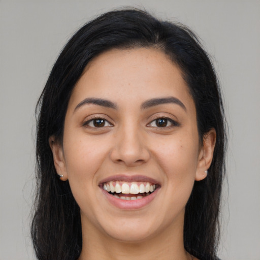 Joyful latino young-adult female with long  brown hair and brown eyes