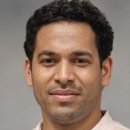 Joyful latino adult male with short  brown hair and brown eyes