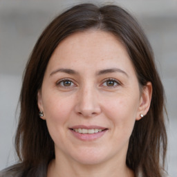 Joyful white adult female with long  brown hair and brown eyes