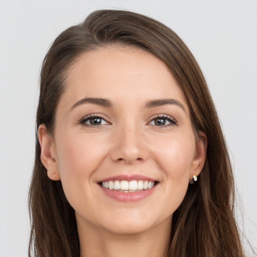 Joyful white young-adult female with long  brown hair and grey eyes