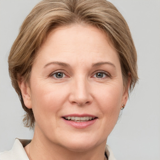 Joyful white adult female with medium  brown hair and grey eyes