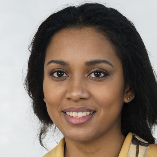 Joyful black young-adult female with long  brown hair and brown eyes