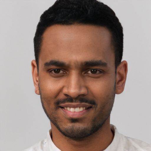 Joyful black young-adult male with short  black hair and brown eyes