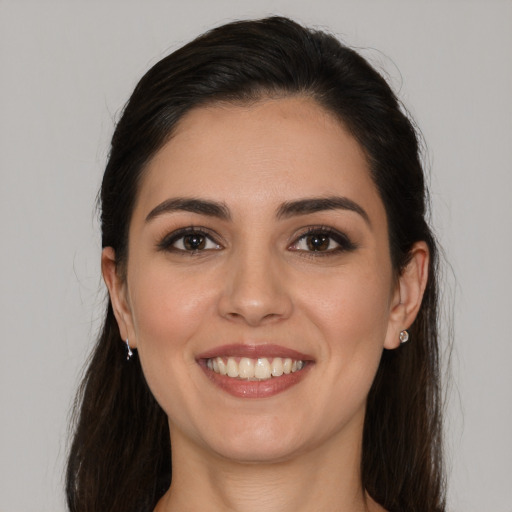 Joyful white young-adult female with long  brown hair and brown eyes