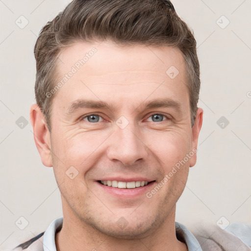 Joyful white young-adult male with short  brown hair and grey eyes