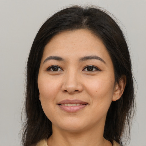 Joyful asian young-adult female with long  brown hair and brown eyes