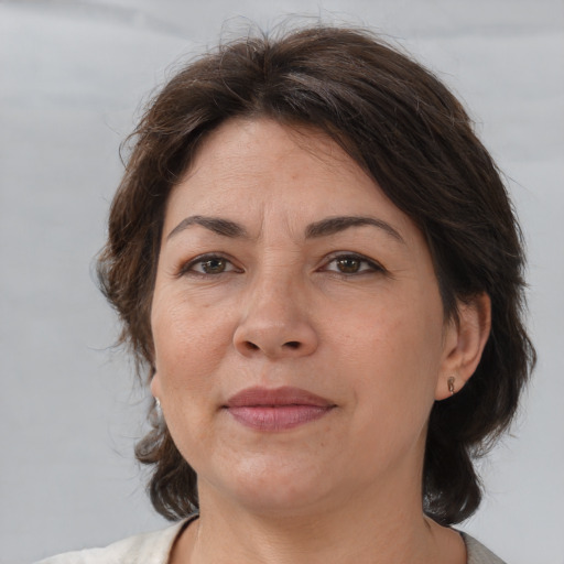 Joyful white adult female with medium  brown hair and brown eyes