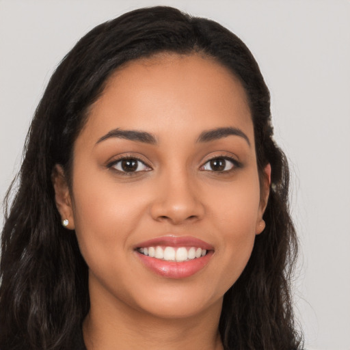 Joyful latino young-adult female with long  brown hair and brown eyes