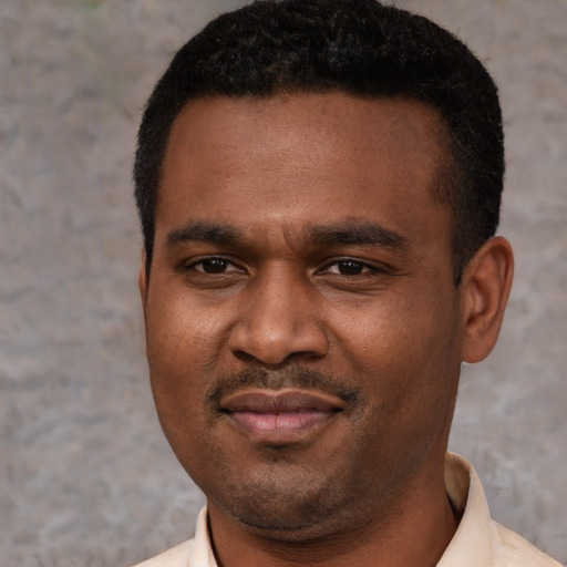 Joyful black young-adult male with short  black hair and brown eyes
