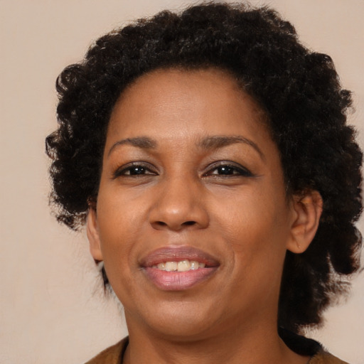 Joyful black adult female with medium  brown hair and brown eyes
