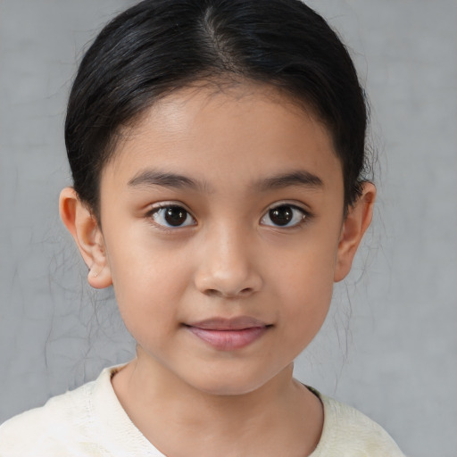 Joyful latino child female with medium  brown hair and brown eyes