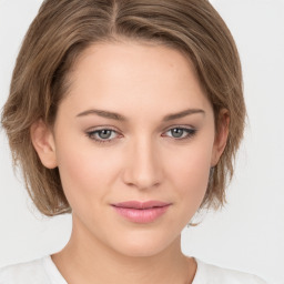 Joyful white young-adult female with medium  brown hair and green eyes