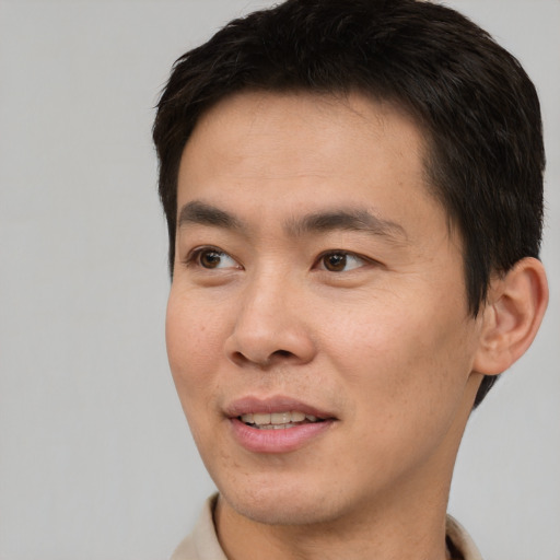 Joyful white young-adult male with short  brown hair and brown eyes
