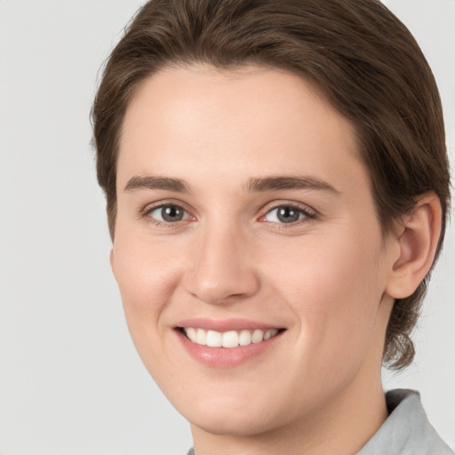 Joyful white young-adult female with medium  brown hair and grey eyes