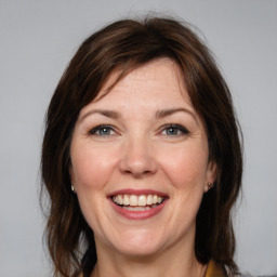 Joyful white adult female with medium  brown hair and grey eyes