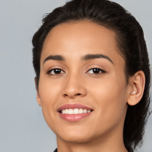 Joyful latino young-adult female with medium  brown hair and brown eyes