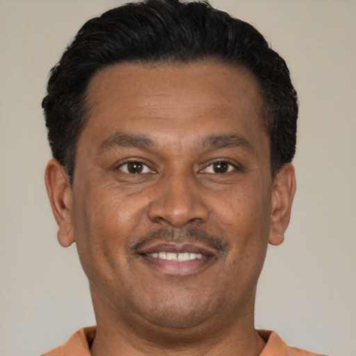 Joyful latino adult male with short  black hair and brown eyes