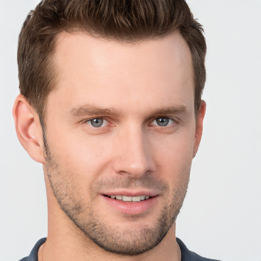 Joyful white young-adult male with short  brown hair and grey eyes