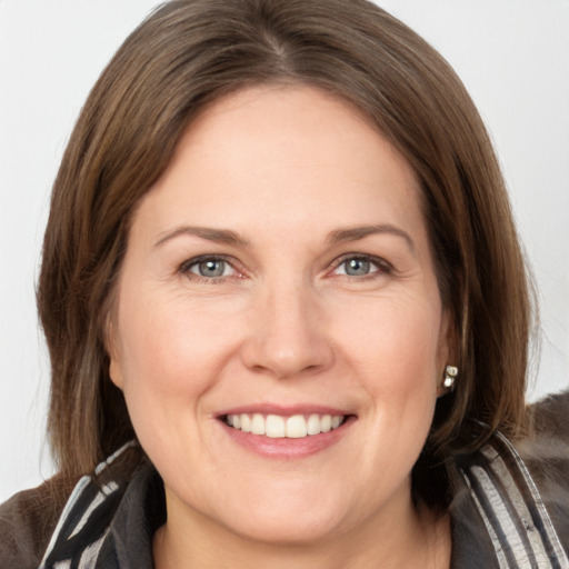 Joyful white young-adult female with medium  brown hair and grey eyes