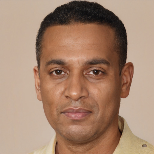 Joyful black adult male with short  black hair and brown eyes