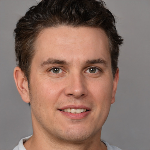 Joyful white adult male with short  brown hair and brown eyes