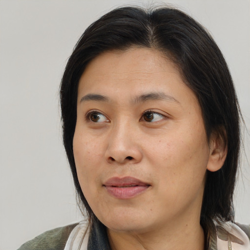 Neutral asian adult female with medium  brown hair and brown eyes