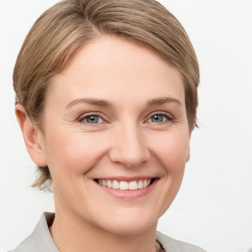 Joyful white young-adult female with medium  brown hair and grey eyes