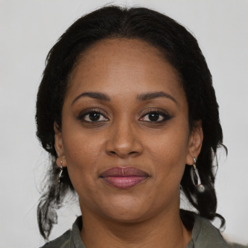 Joyful black adult female with medium  brown hair and brown eyes