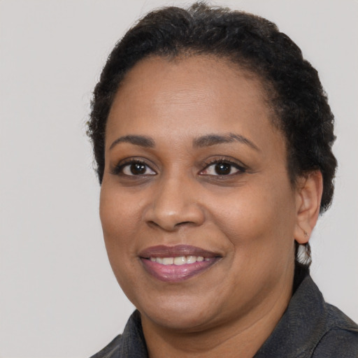 Joyful black adult female with short  brown hair and brown eyes