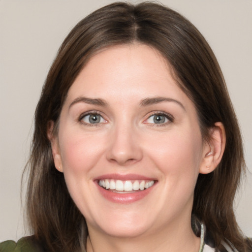 Joyful white young-adult female with medium  brown hair and grey eyes