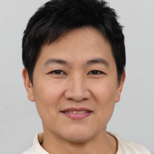 Joyful asian adult male with short  brown hair and brown eyes