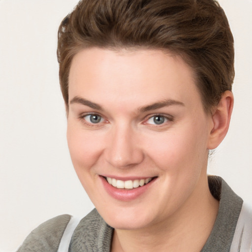 Joyful white young-adult female with short  brown hair and grey eyes