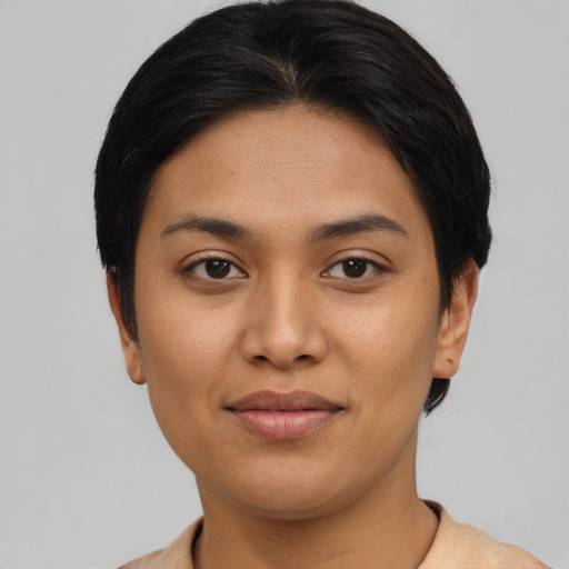Joyful latino young-adult female with short  black hair and brown eyes