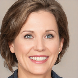 Joyful white adult female with medium  brown hair and grey eyes