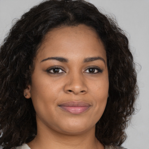 Joyful black young-adult female with long  brown hair and brown eyes