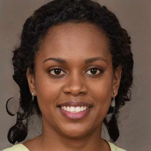 Joyful black young-adult female with medium  brown hair and brown eyes