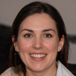 Joyful white adult female with medium  brown hair and blue eyes