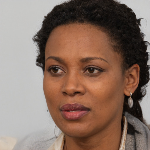 Joyful black adult female with short  black hair and brown eyes