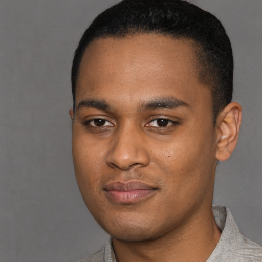 Joyful black young-adult male with short  black hair and brown eyes