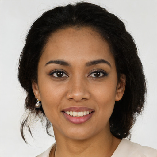 Joyful latino young-adult female with medium  brown hair and brown eyes