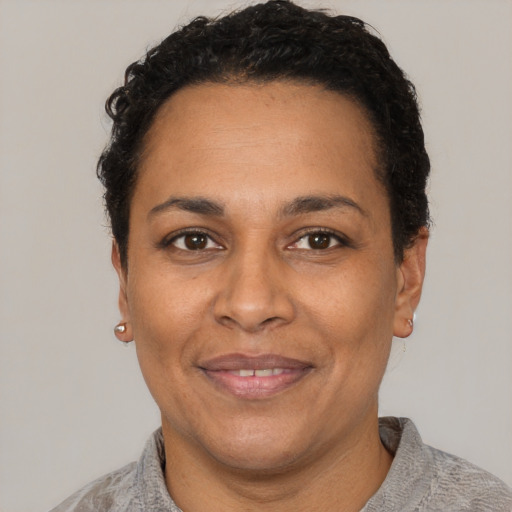 Joyful black adult female with short  brown hair and brown eyes