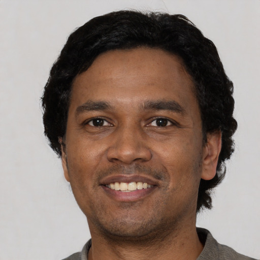 Joyful latino adult male with short  black hair and brown eyes